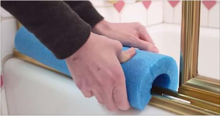 shower hacks - person covering shower door tracks with a pool noodle