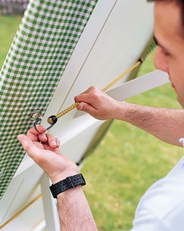 bungee cord uses - person anchoring down the table cloth using grommets and a bungee cord