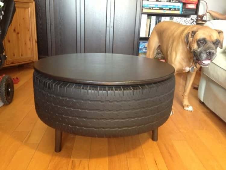 DIY recycled tire coffee table and a dog standing next to it