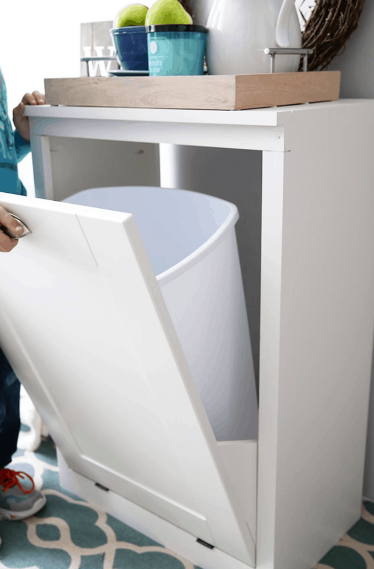 clever organization ideas with a white cabinet with pull out door and a white trash can inside. nice to hide it away. 