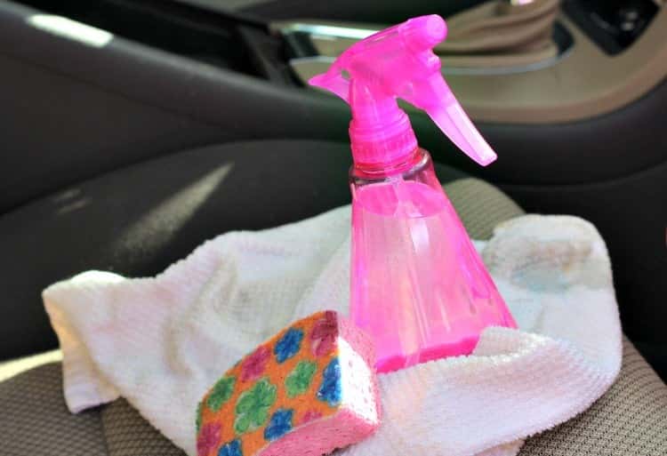upholstery tips - spray bottle on a cloth and next to a cleaning sponge