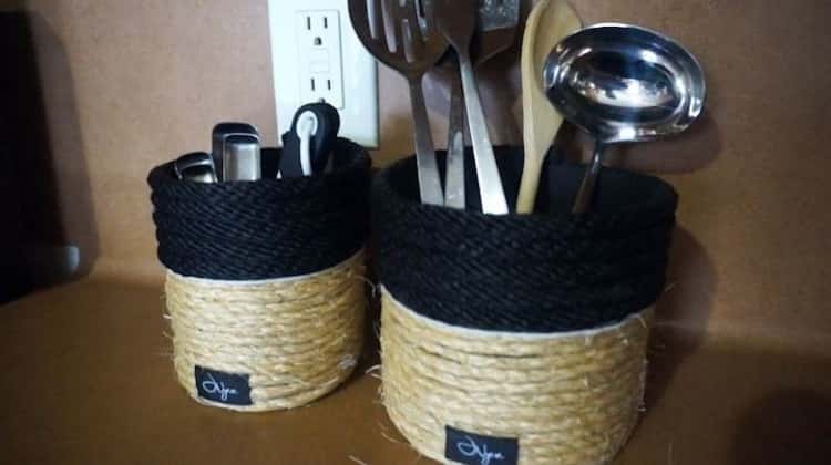 empty oatmeal container cut in half, wrapped in rope storing kitchen utensils