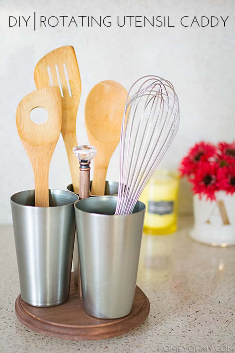 rotating utensil caddy inside metal cups with kitchen spoons and whisk in side