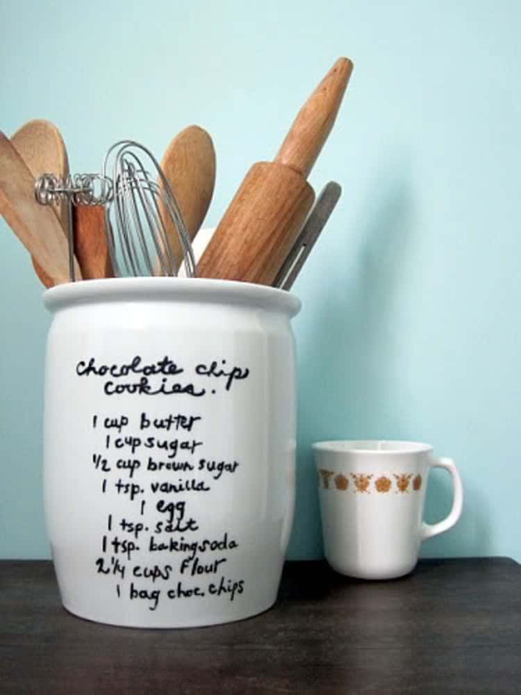 white vase with chocolate chip cookie recipe written on outside and kitchen utensils inside