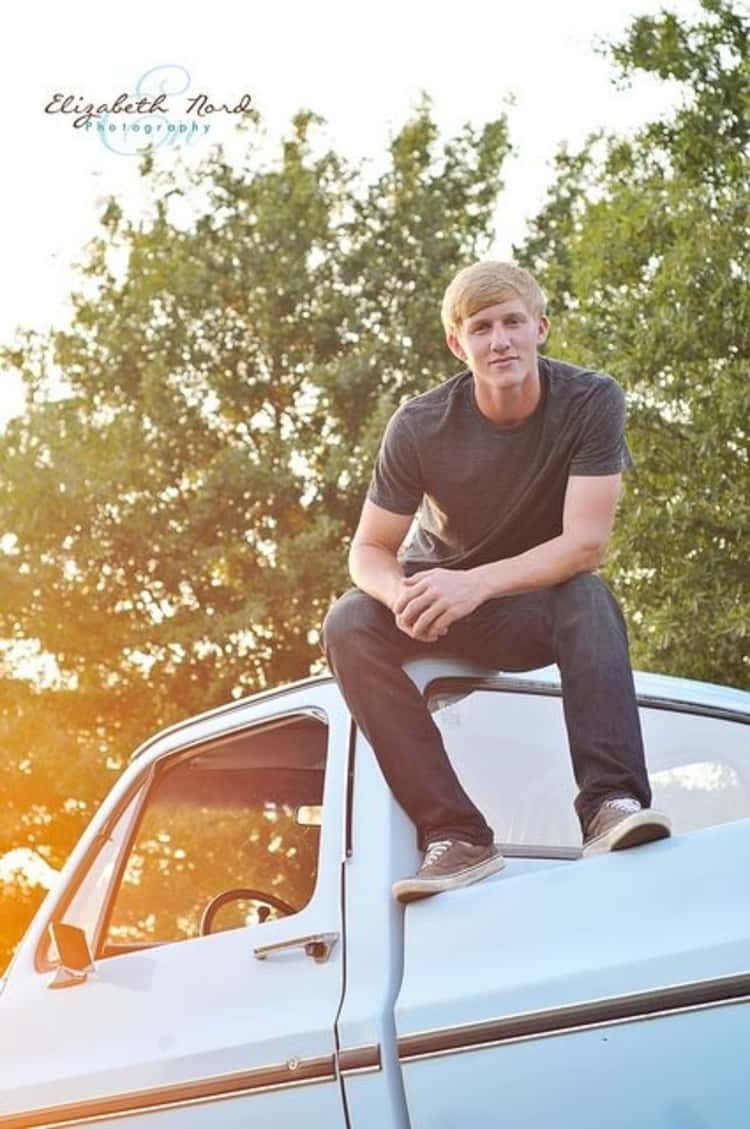 senior picture idea for guys - guy seated on top of a light blue pick up truck. 