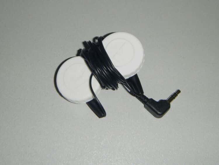 earbuds rolled around contact lens container