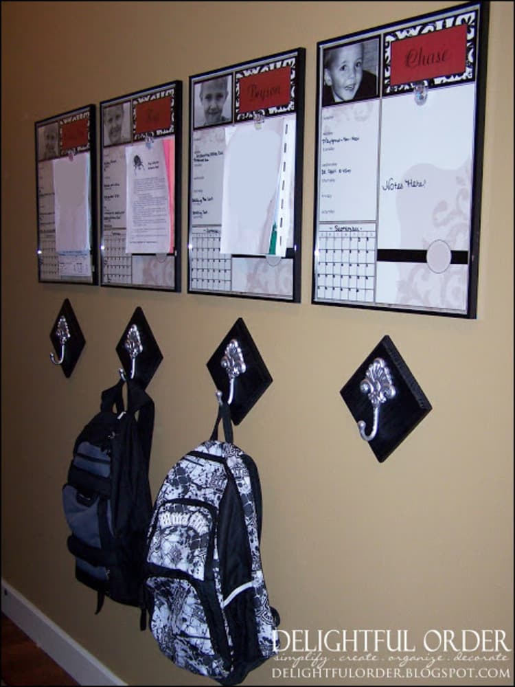 Entryway Command Center with poster frames for each kid with individual calendars and schedules and hooks under them for jackets and backpacks