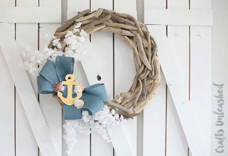 driftwood wreath with a blue bow a yellow anchor and white flowers