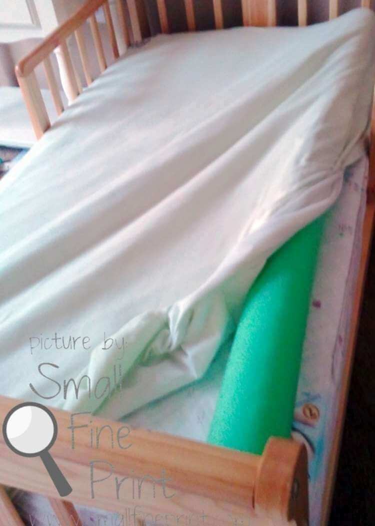 uses for pool noodles- a wide pool noodle tucked under a fitted sheet in a child's bed to help prevent them from rolling out of bed while sleeping