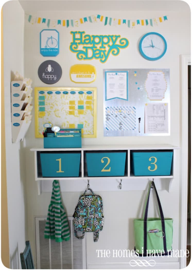 hallway organization center for the family in a corner space with folder organizers, calendar, whiteboard, bins and hooks for storing bags, backpacks and jackets