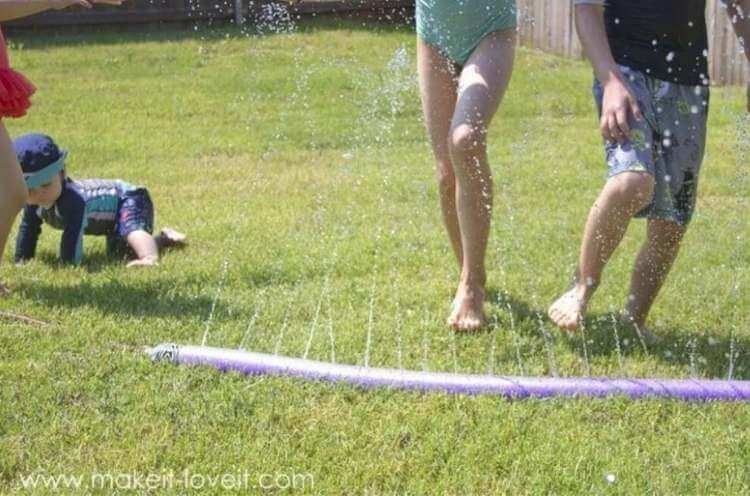 FUN uses for pool noodles- kids running through a sprinkler made by sticking a hose into a pool noodle that hale holes cut into it which has the water shoot straight up 
