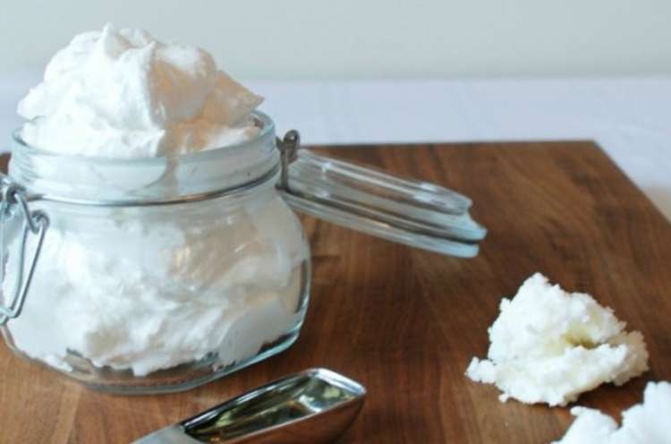 cream butter on a jar on top a wooden table