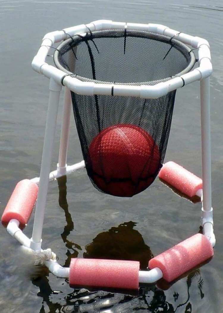 DIY uses for pool noodles- a floating basketball hoop made from white pvc piping, black netting, zip ties with cut pieces of pool noodles attached to the base so it will flaot