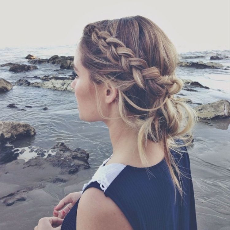 Here we have a great way to keep your hair out of the wind with a dutch braid on either side, pulled back with a messy bottom bun.