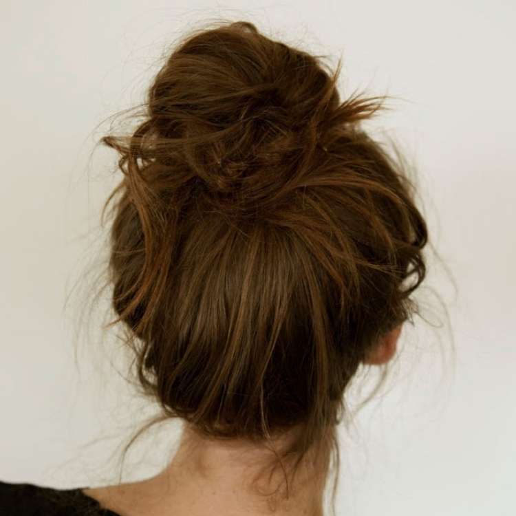  Easy Bun Hairstyles back of a brown haired woman's head, with a messy bun