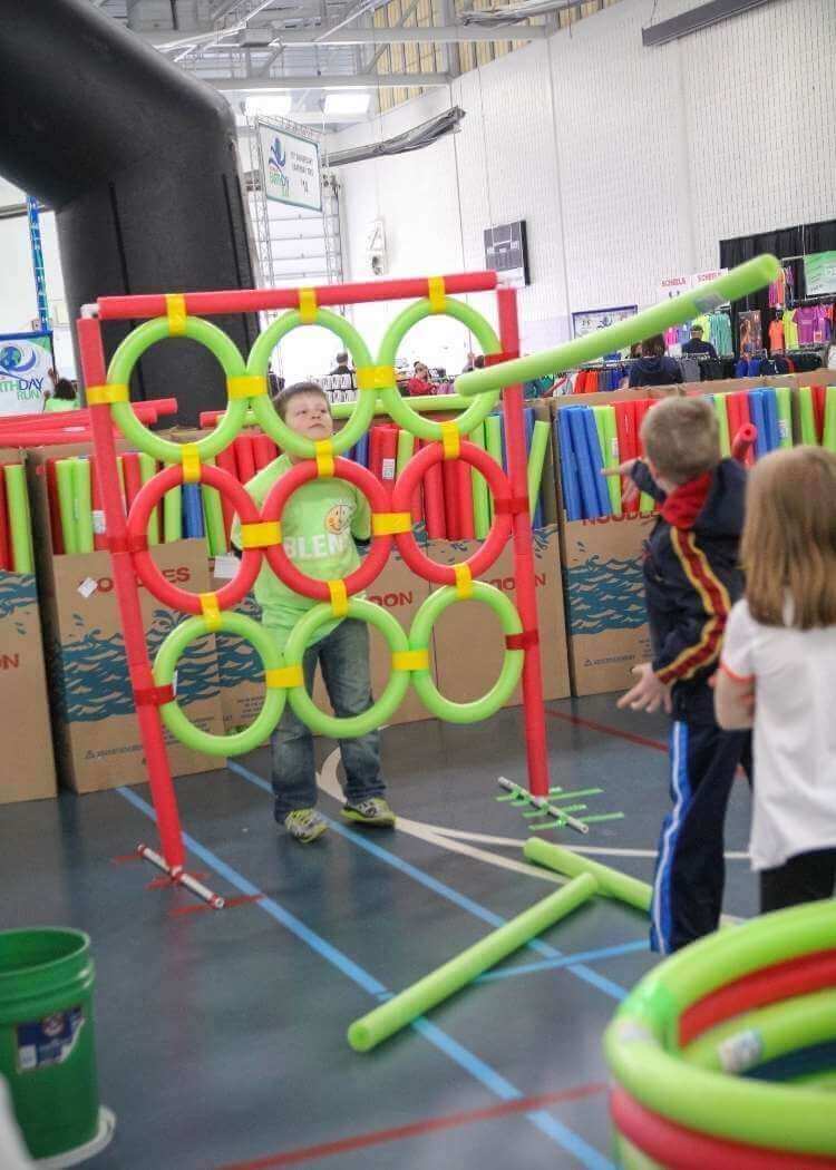 uses for pool noodles- kids playing toss with a tic tac toes style target made of pvc pipe and covered in pool noodles