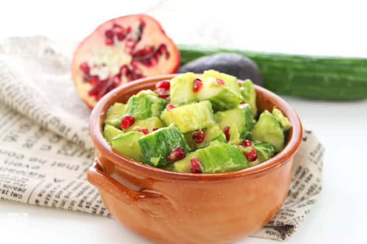 plant-based meals - bowl filled with cubes of avocado, cucumber and pomegranate seeds.