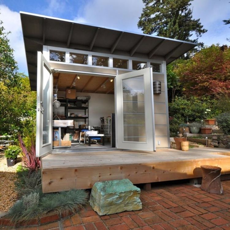 Modern shed remodel with wood siding and deck to create and spacious and warm office area outdoors.