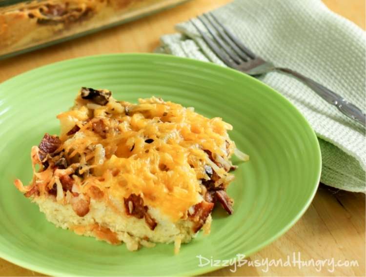 OneCrazyHouse Hot Breakfasts Bacon Breakfast Caserrole Slice on a Plate with casserole dish in background