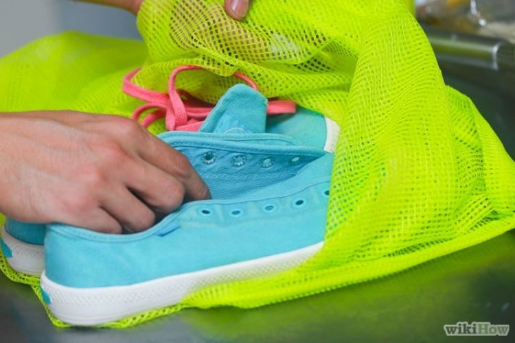 blue tennis shoes in a neon green laundry bag