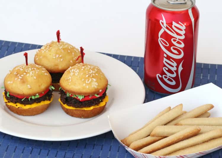 Hamburgers made from cupcakes and fries made from cookies with a coke soda can on the side 