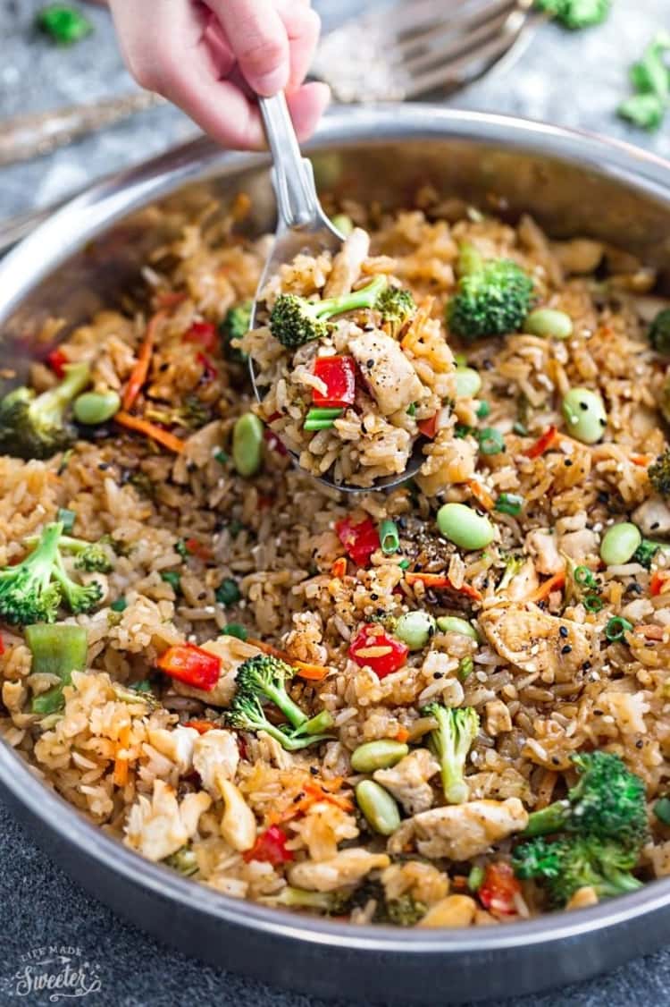 close up of a deep cooking pan full of teriyaki chicken with rice and broccoli  