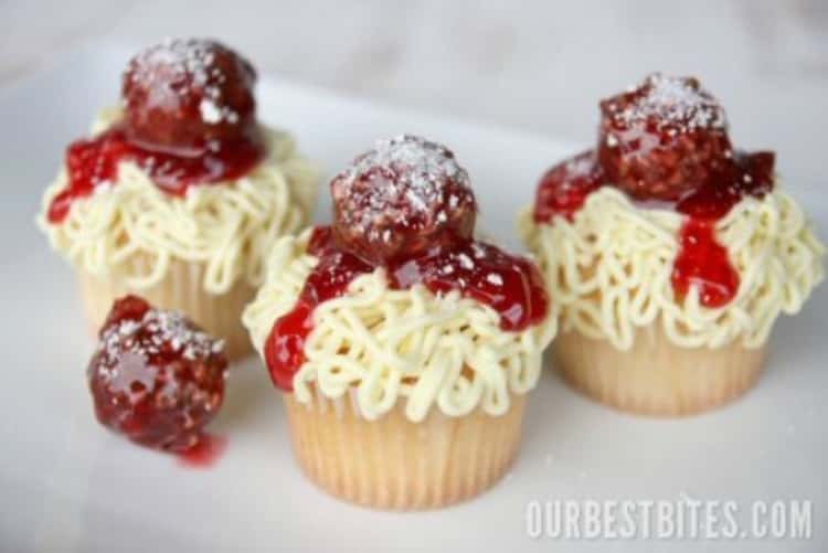 Cupcakes topped with cream cheese frosting made to look like noodles with a Ferrero Rocher dipped in plum jam for the meatball