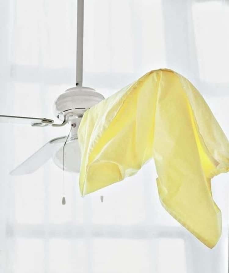 A pillowcase on the blade of a ceiling fan used to clean it 