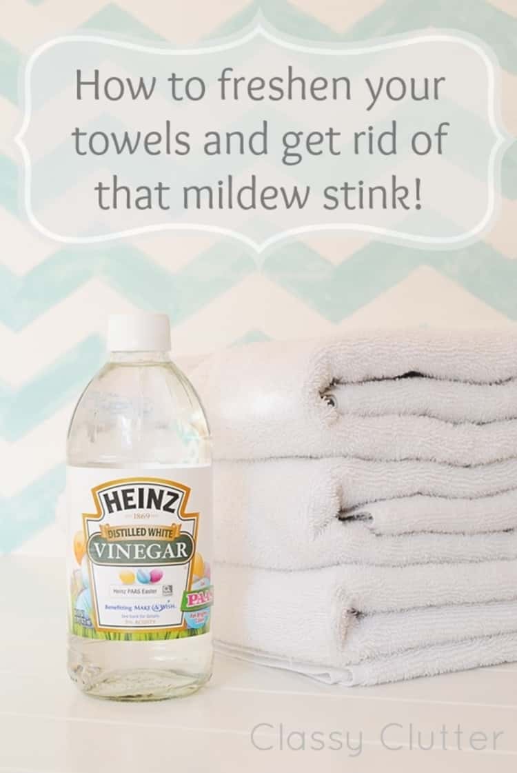 Vinegar used to get rid of mildew stink- a photo of a bottle of vinegar beside a stack of folded towels