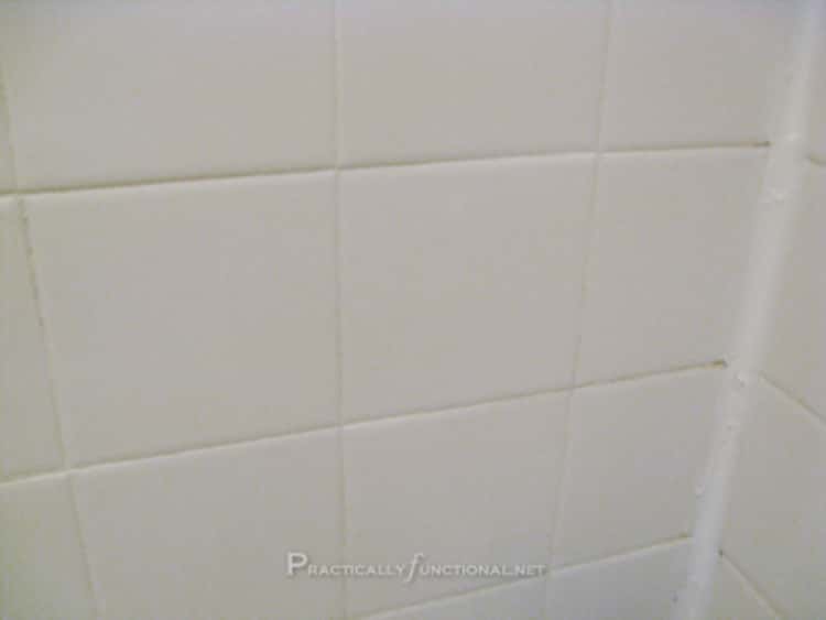 A photo of shower tiles before and after cleaning with the magic homemade grout cleaner