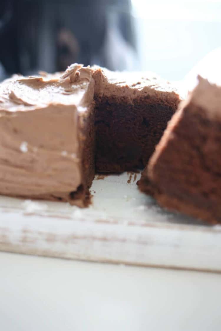 Air fryer chocolate cake with chocolate icing; one slice cut.