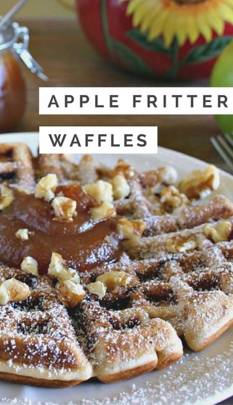 a plate full of apple fritter waffles topped with a dollop of apple butter and sprinkled with powdered sugar and toasted nuts