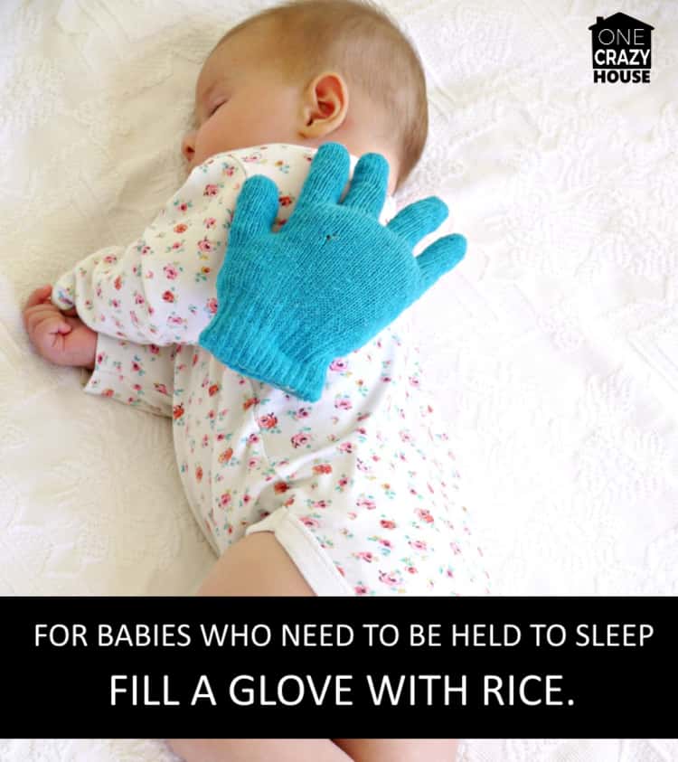 weighted hand on sleeping baby which is a baby hack for babies who need to be held to sleep