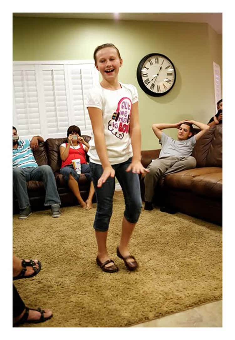 happy girl parading her new clothes in front of her family on the first day back to school eve. 