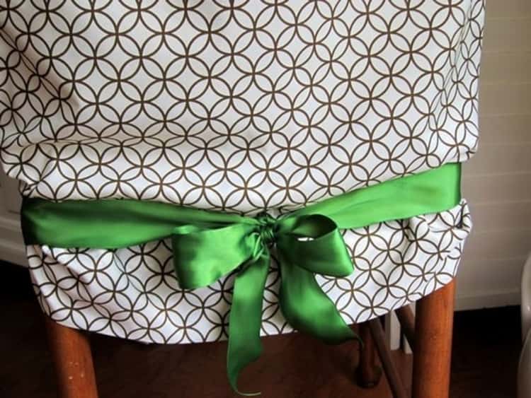 a pillowcase slid on the back of a chair and tied with a green ribbon 