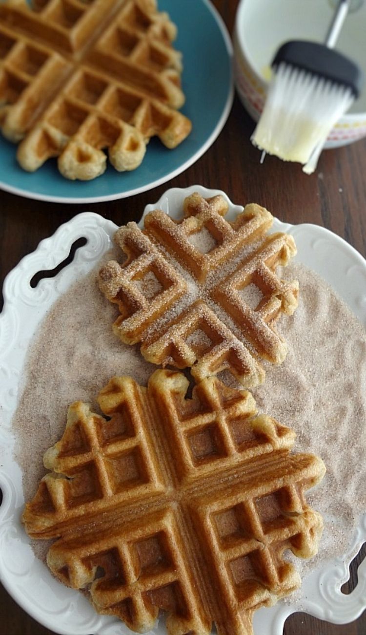 a plate of churro waffles laying on top of cinnamon sugar