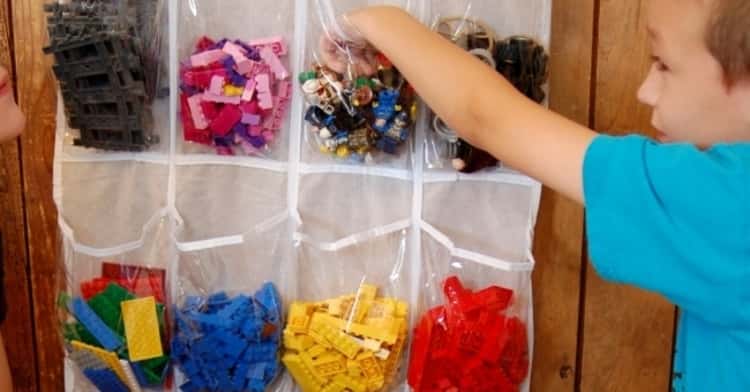 kid putting away or getting toys out of clear shoe organizer hang on the closet door 