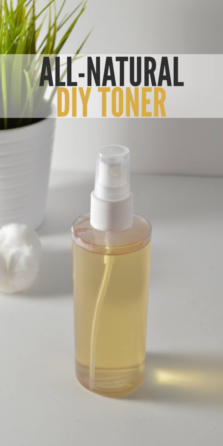 An image of homemade diy skin toner in a spray bottle. Background is a white counter. Next to the toner is a cotton ball and a green plant in a white pot. The words "All-Natural DIY Toner" are above the spray bottle.