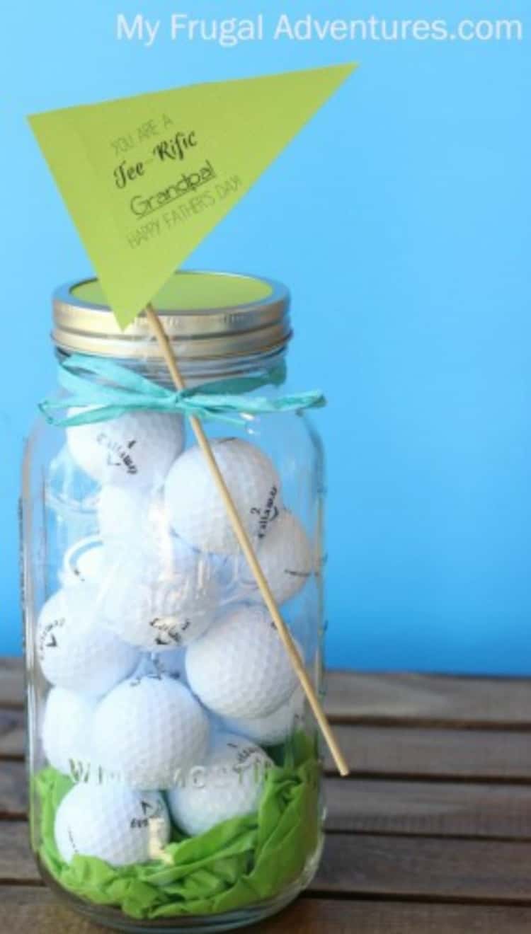 a mason jar full of golf balls and a little flag on a skewer reading "You're a Tee-Rific Grandpa! 