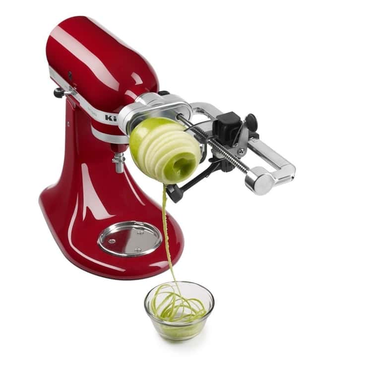 Amazing Kitchen Aid Mixer Attachments - an apple being peeled by the spiralizer peeling attachment on a Kitchen Aid