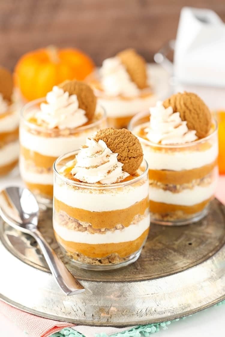 Photo of no-bake pumpkin pies in a jar layered with whipped cream.