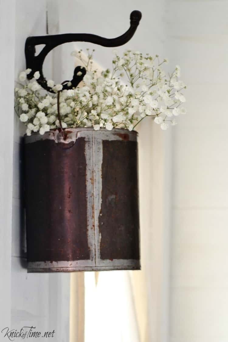 a rusty paint can in reuse as a hanging basket for baby's breath plant