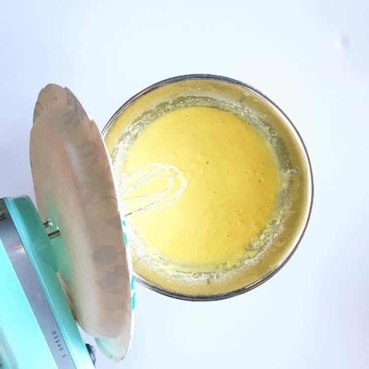 A paper plate in use to cover the mixing bowl to avoid spillage of dough when using the Kitchen Aid 