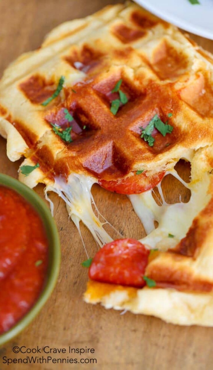 pizza waffles on a cutting board with a side of marinara sauce