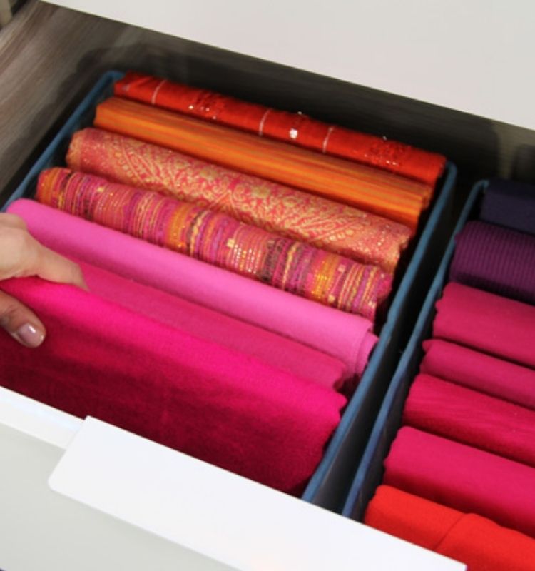 red colored scarves folded and lined upward in an open drawer