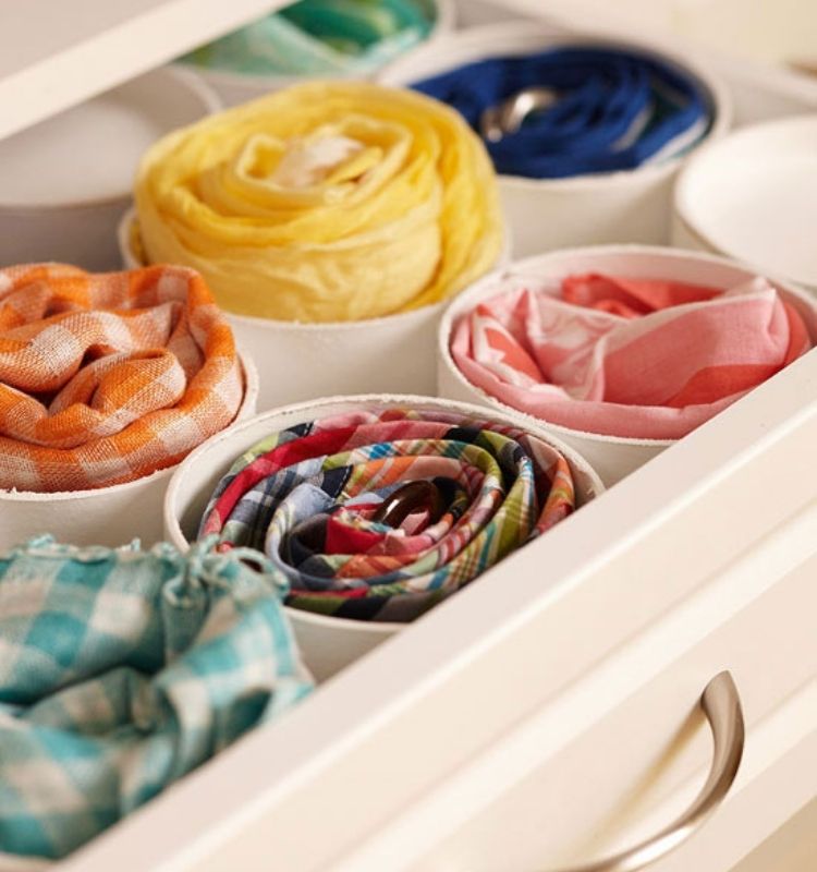 scarves rolled up and stored in a piece of pvc pipe in a drawer