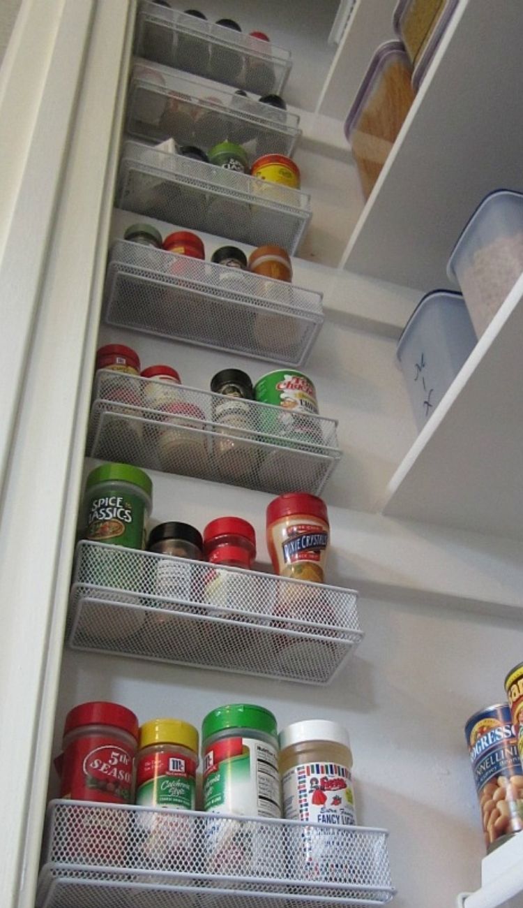 spices in their original jars in metal racks attached to a wall