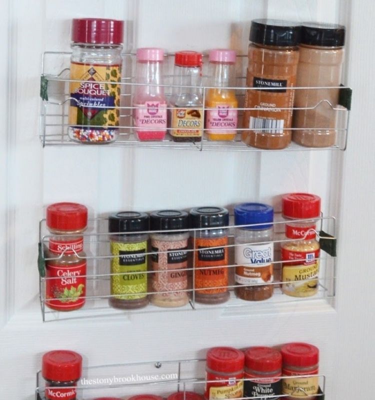 spices in their original jars lined in a DIY rack attached to a door