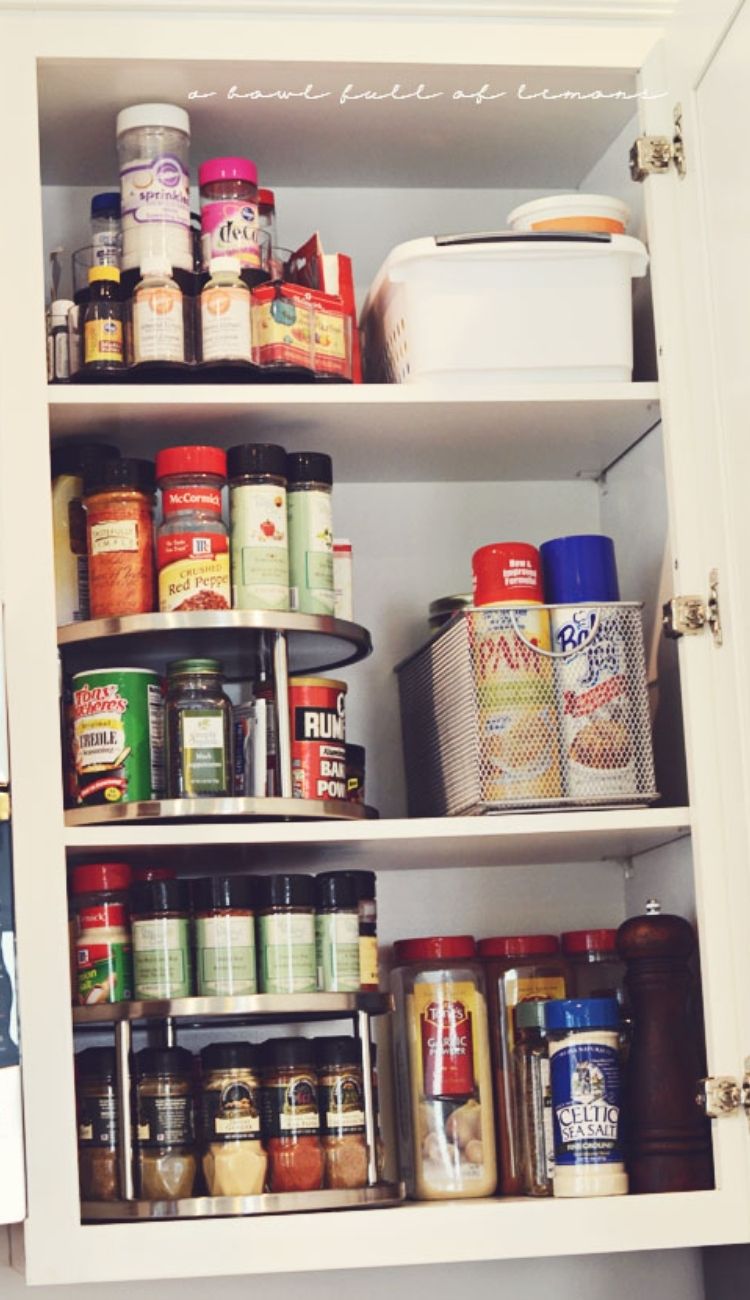 spices on a lazy susan in a kitchen cabinet