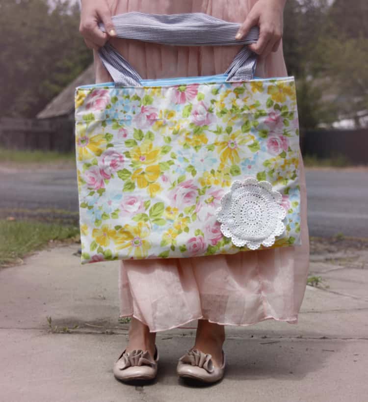 person holding a tote bag made by repurposing a flowery pillowcase